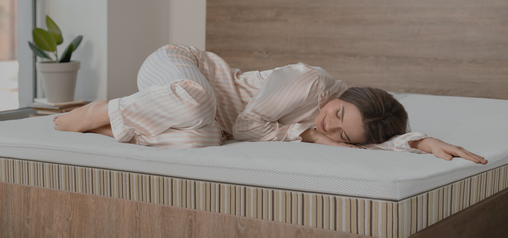 Woman cuddled on her Essentia organic mattress