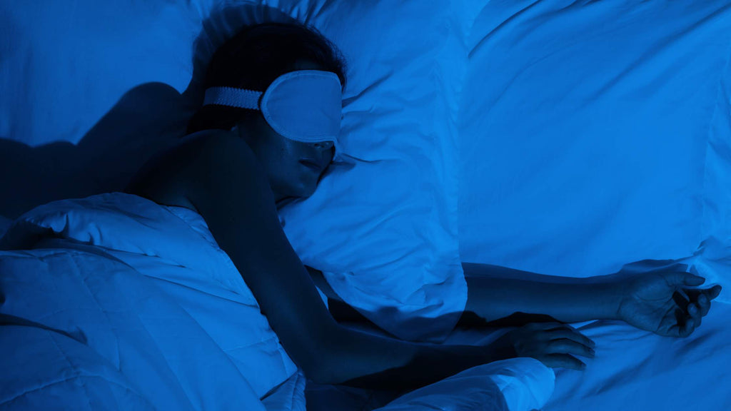 Woman sleeping at night wearing a sleep mask.