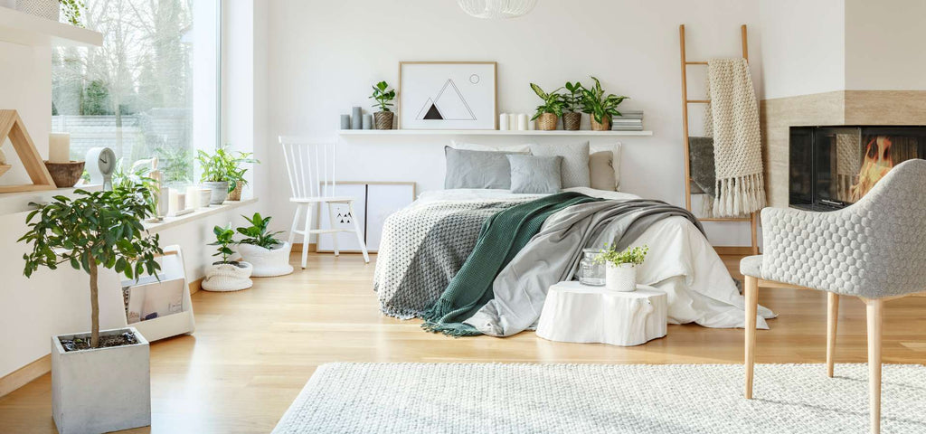 Clean bedroom with lots of green plants.