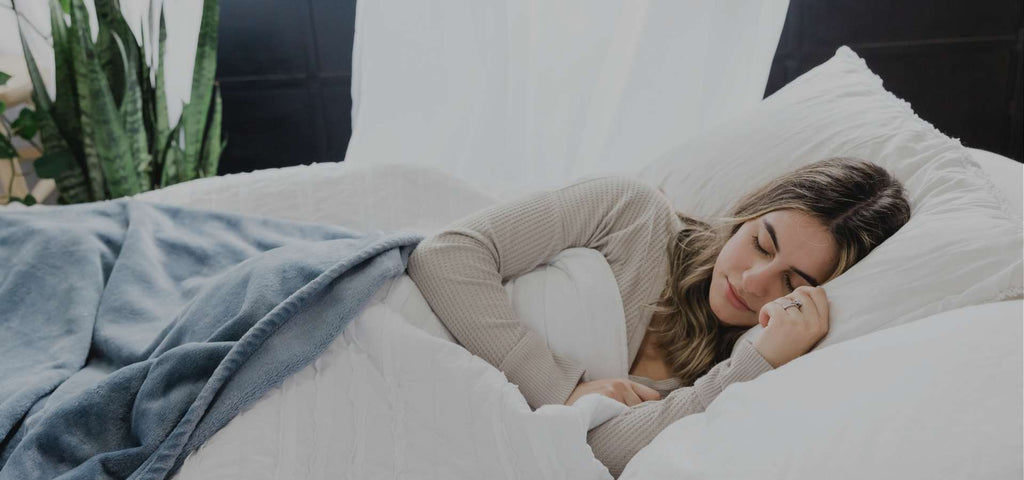 Woman sleeping covered with a blue blanket.