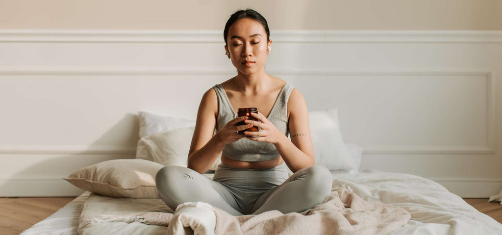 Woman sitting on bed meditating