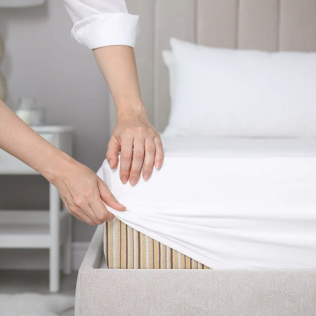 Woman putting GOTS certified organic sheets on her Essentia organic mattress.