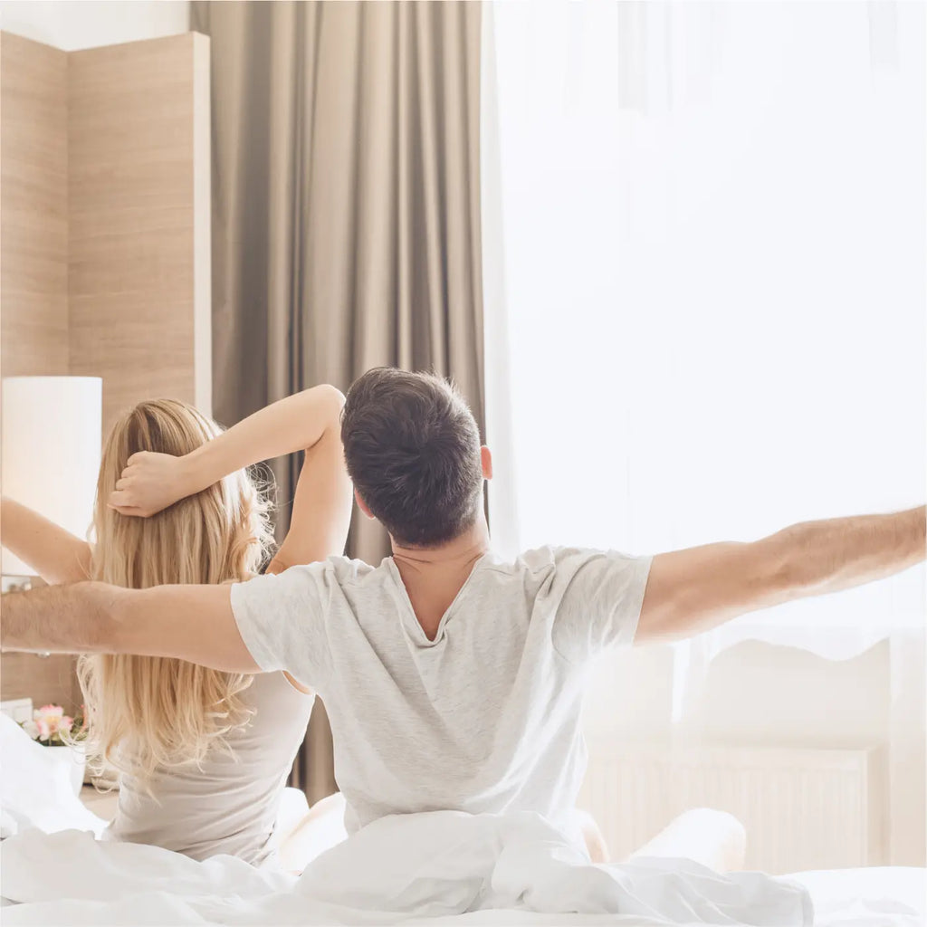 Couple waking up to a new_day_sitting_on_an_Essentia Stay Well Hotel