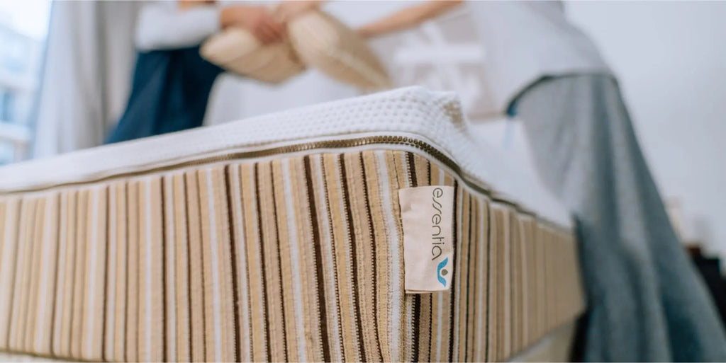 Couple making the bed with an Essentia lifestyle mattress
