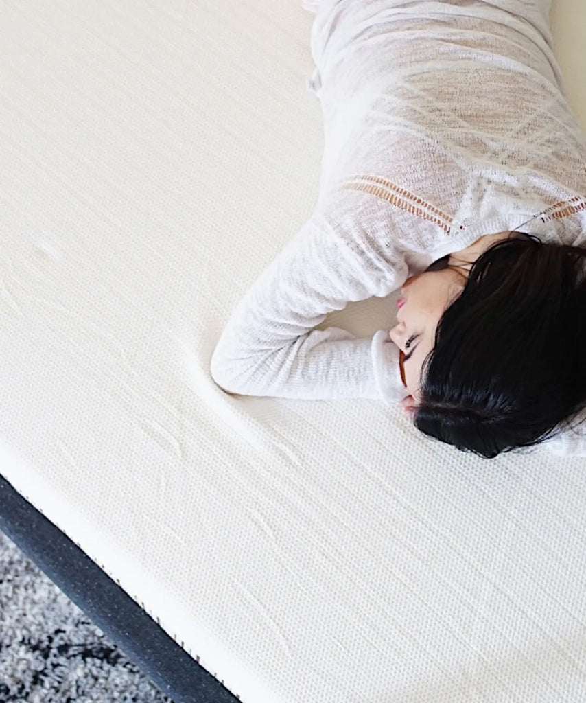 Woman lying on Essentia organic bed