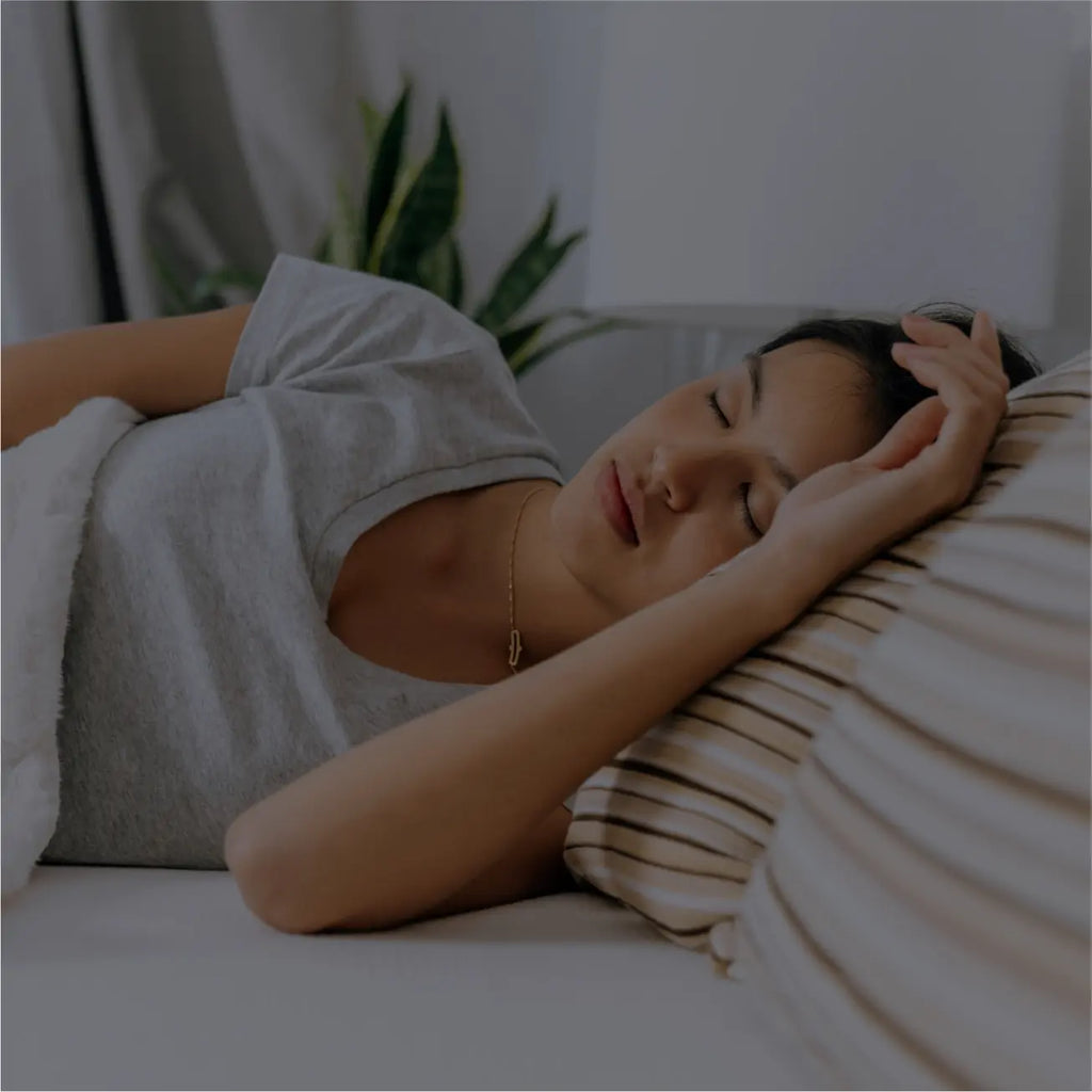 Young woman deep asleep on an Essentia mattress in a dark room