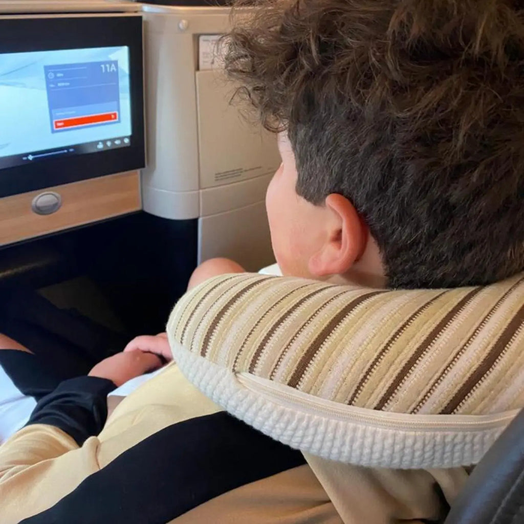 Teenager using Essentia organic latex travel pillow on plane