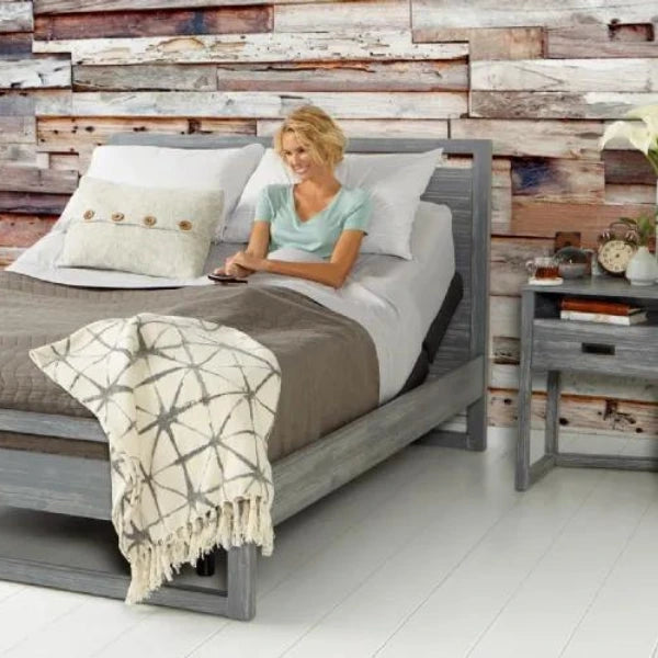 Woman in bed using a Rize Adjustable foundation inside her bed frame