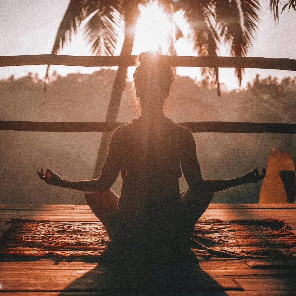 woman practicing yoga with the sunrise
