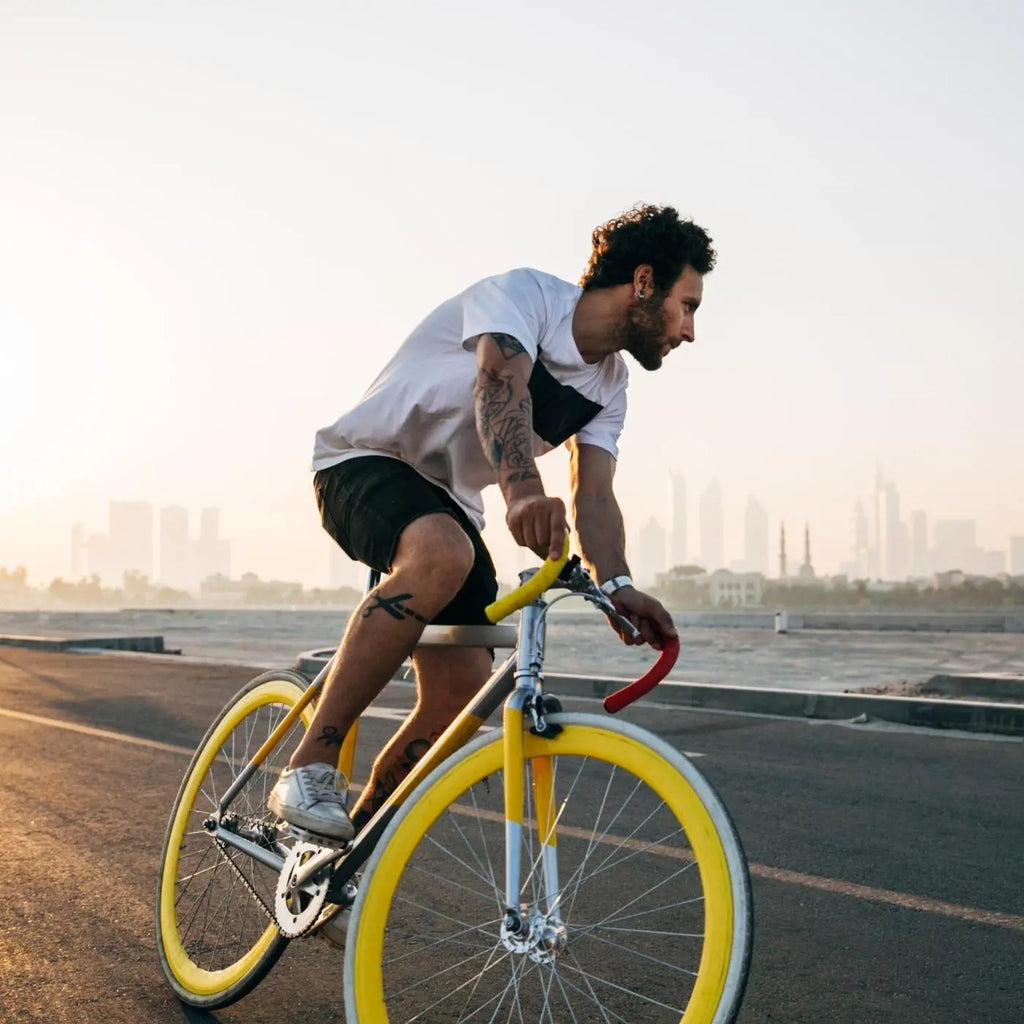 young man riding a yellow bike at sunrise